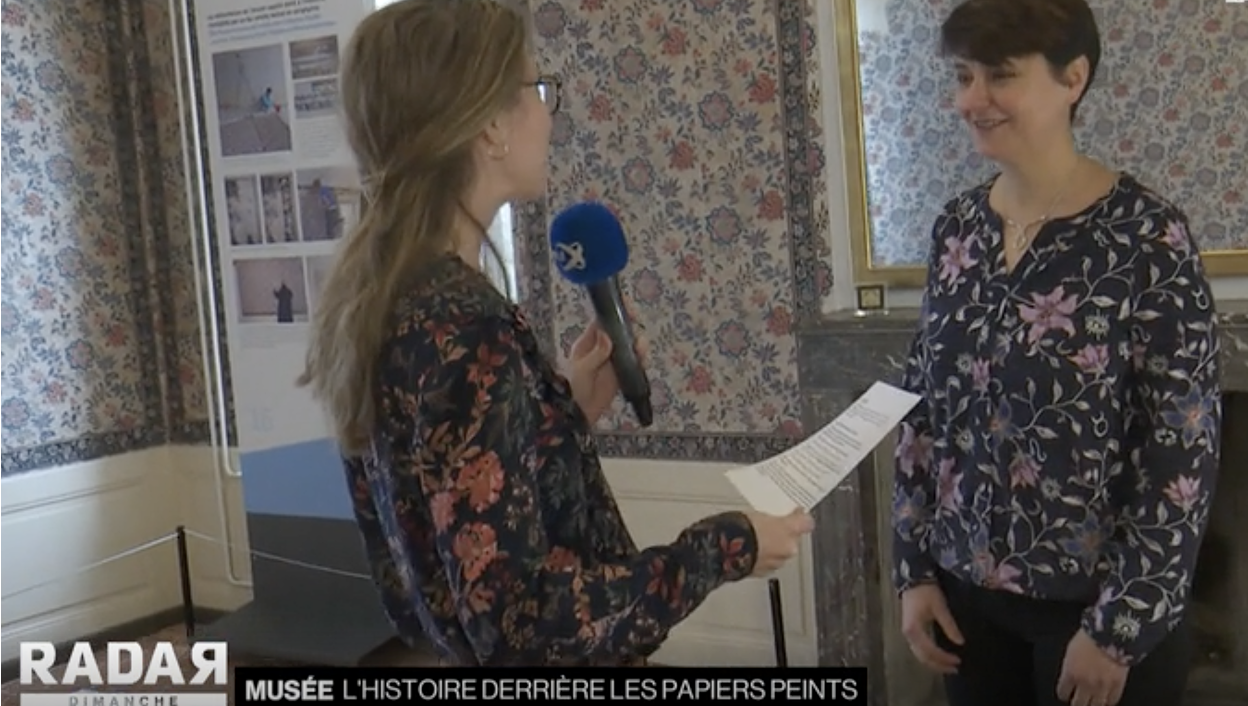 Interview de Laurence Ansermet du Musée du Papier peint par La Télé dans l'émission Radar du 13 mars 2022, entourée de papiers peints fleuris historiques.