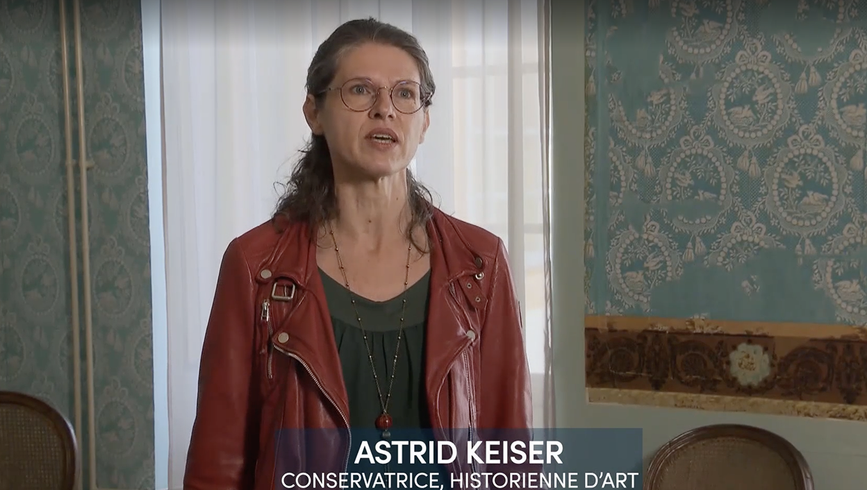 Astrid Kaiser, conservatrice et historienne d'art du Musée du Papier peint, lors d'une interview pour la RTS le 20 avril 2022, avec des papiers peints anciens en arrière-plan.